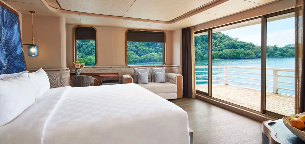 Luxurious bedroom with elegant decor, offering a stunning view of the tranquil water from a luxury yacht.