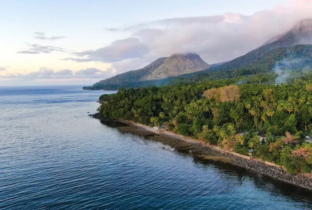 A breathtaking aerial view of Camiguin Island showcasing its stunning beach and majestic mountains.