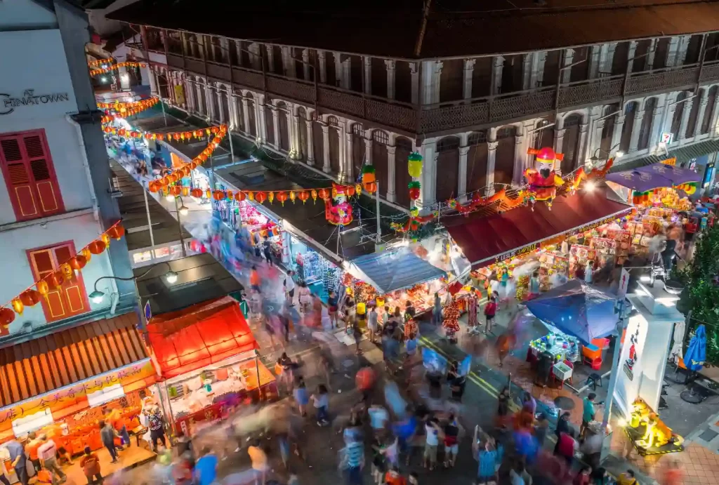 Bustling Chinatown market in Singapore, filled with people exploring vibrant stalls and enjoying the lively atmosphere.