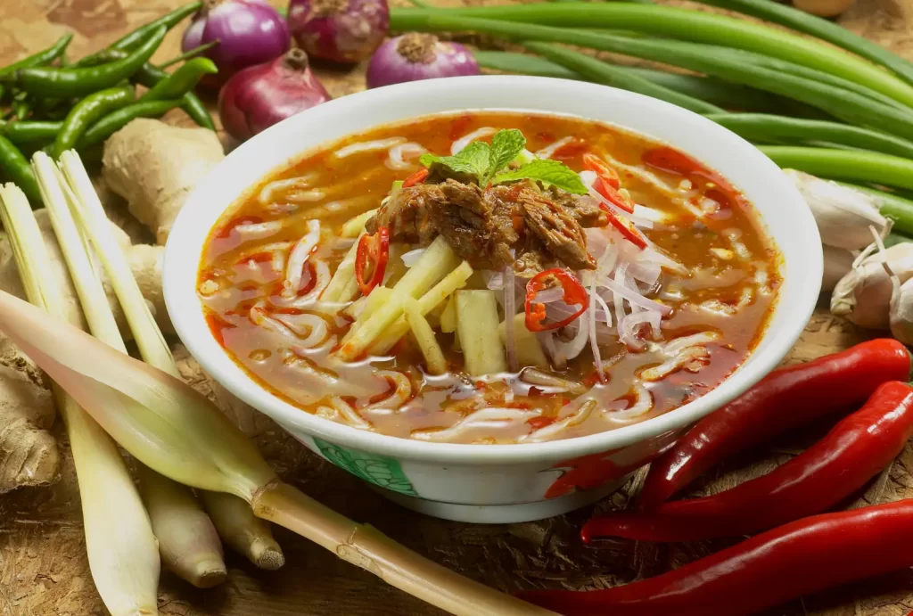 A vibrant bowl of Curry Laksa filled with fresh vegetables and aromatic ingredients