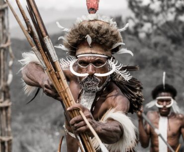 Black and white photograph featuring a Dani Warriors man, skillfully holding a bow and arrow, representing tribal culture.