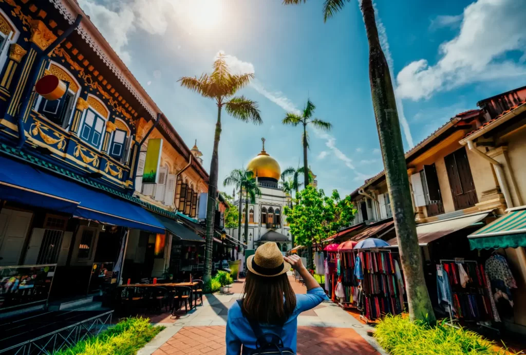 Young woman traveler traveling into The Masjid Sultan mosque located in Kampong Glam in Singapore city.