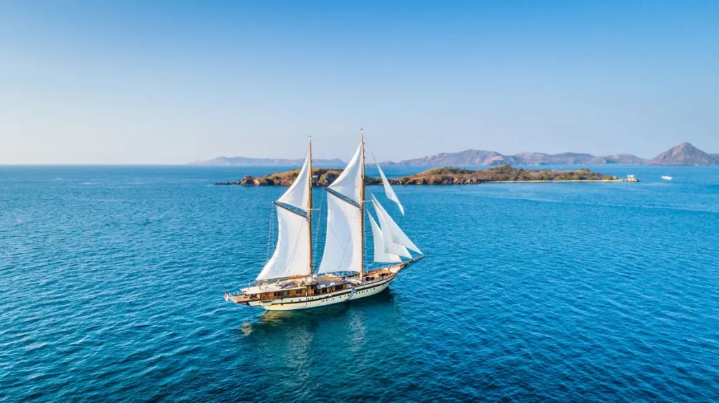 A luxury yacht glides through the open ocean under a clear blue sky, embodying freedom and adventure on the water.