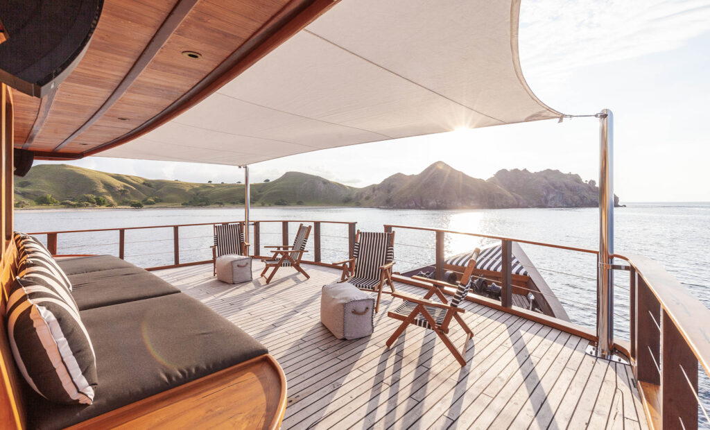 A serene boat deck featuring lounge chairs and a sunroof, perfect for relaxing under the sun during your Voyage.