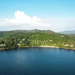 Aerial view of a luxury resort nestled in tropical forest on a private peninsula in phuket, Thailand, surrounded by calm blue Andaman Sea waters