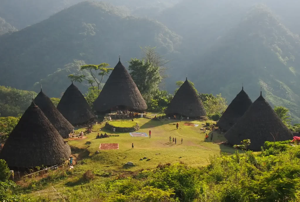 Scenic view of Wae Rebo Village in Flores, Indonesia, featuring traditional thatched huts nestled in the mountains.