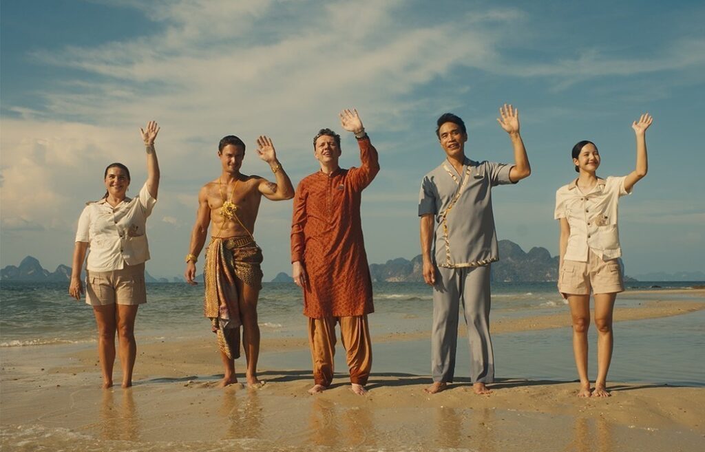 5. People standing on the beach, waving their hands in excitement, enjoying a sunny day by the ocean.