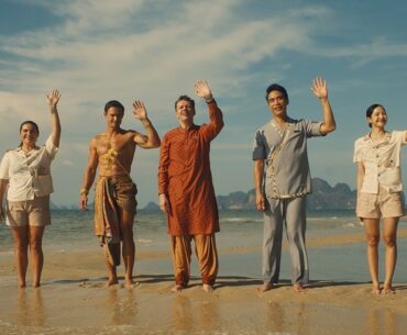 5. People standing on the beach, waving their hands in excitement, enjoying a sunny day by the ocean.