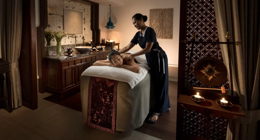 A woman receives a relaxing back massage at the luxurious Anantara Layan Phuket Resort spa. This image highlights premium wellness experiences for travelers