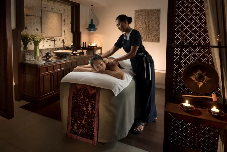 A woman receives a relaxing back massage at the luxurious Anantara Layan Phuket Resort spa. This image highlights premium wellness experiences for travelers