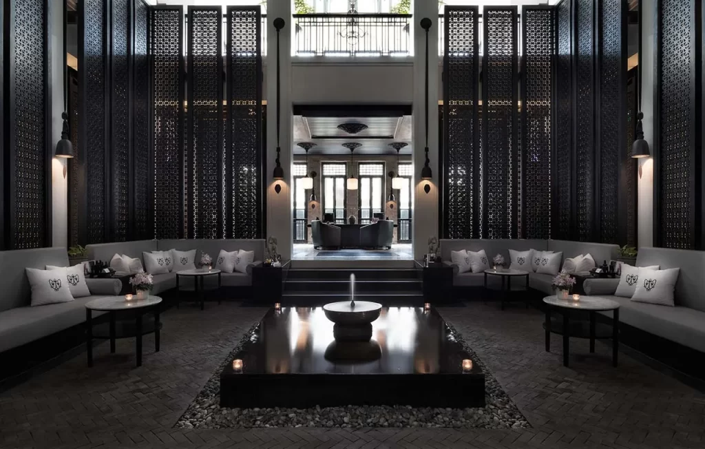 The soaring reception hall of Opium Spa , with floor-to-ceiling carved lattice screens, a central reflecting pool, and candlelit lounges — among the most architecturally dramatic spa experiences in Southeast Asia