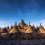 The ancient Borobudur Temple in Central Java under a clear blue sky. A highlight of exclusive cultural Indonesia tours and luxury Indonesia holidays curated by our expert DMC.