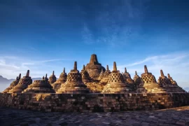 The ancient Borobudur Temple in Central Java under a clear blue sky. A highlight of exclusive cultural Indonesia tours and luxury Indonesia holidays curated by our expert DMC.