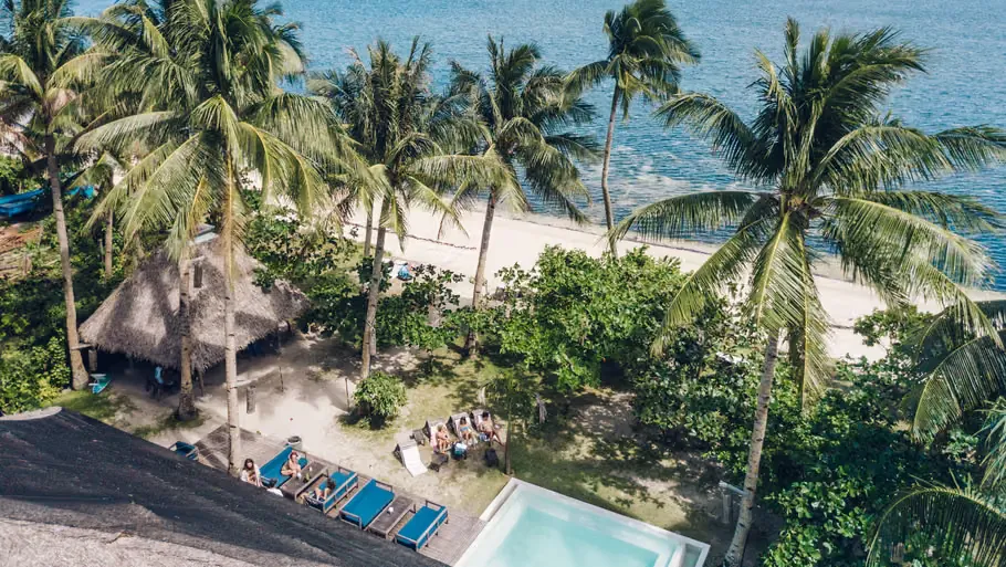 Aerial view of Bravo Beach Resort's beachfront pool and villas on General Luna beach, Siargao.