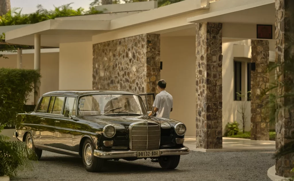 Chauffeur waiting beside a classic Mercedes at the entrance of Amansara, Siem Reap, Cambodia