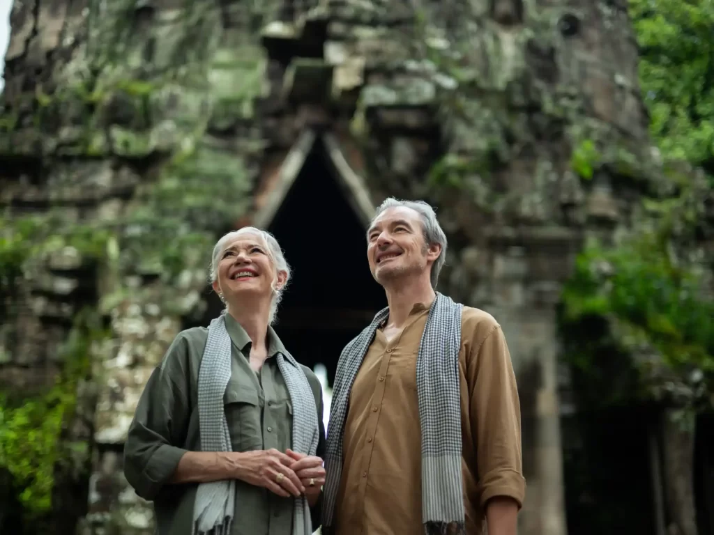 Mature couple admiring a jungle-covered stone gate at Angkor Thom, Cambodia. Photo courtesy of Park Hyatt Siem Reap