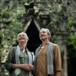 Mature couple admiring a jungle-covered stone gate at Angkor Thom, Cambodia. Photo courtesy of Park Hyatt Siem Reap