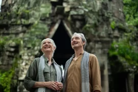 Mature couple admiring a jungle-covered stone gate at Angkor Thom, Cambodia. Photo courtesy of Park Hyatt Siem Reap