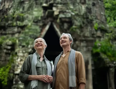Mature couple admiring a jungle-covered stone gate at Angkor Thom, Cambodia. Photo courtesy of Park Hyatt Siem Reap