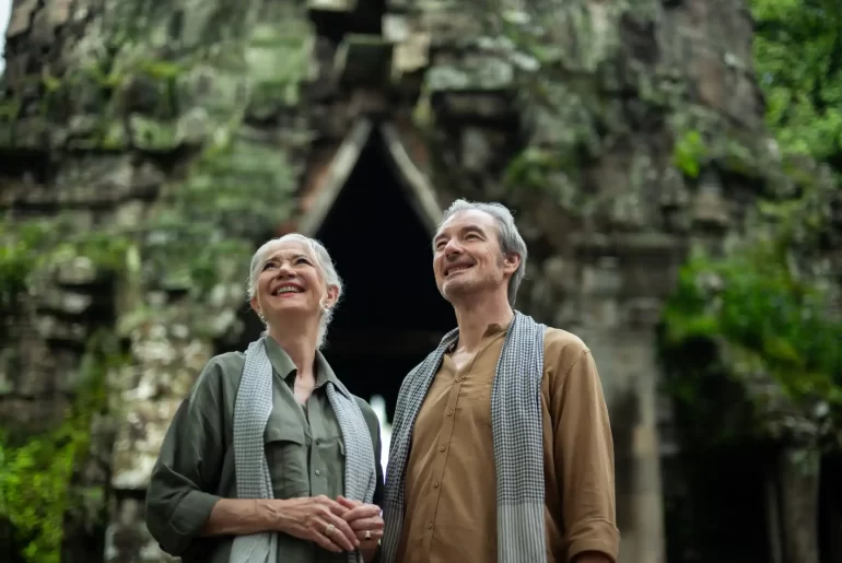 Mature couple admiring a jungle-covered stone gate at Angkor Thom, Cambodia. Photo courtesy of Park Hyatt Siem Reap
