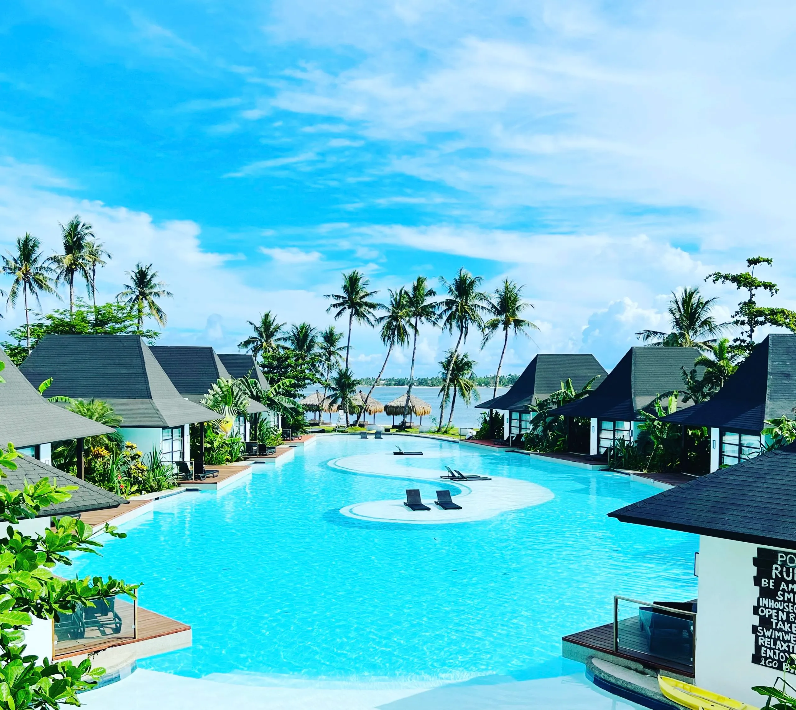 Poolside villas and palm-lined pool at Siargao Bleu Resort & Spa near Cloud 9, Siargao.
