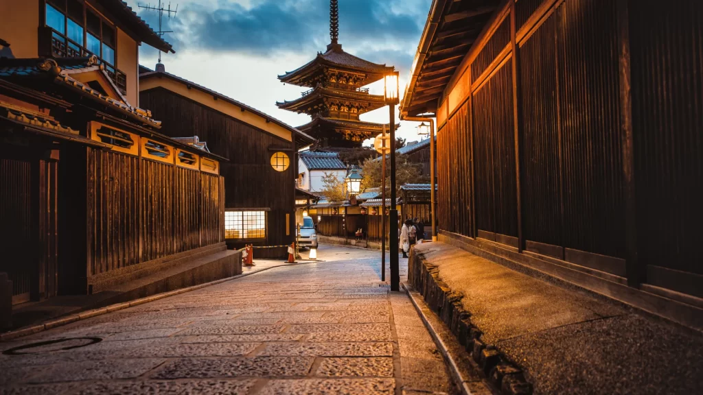 The cobblestone lanes of Higashiyama at dusk, Kyoto, with the five-storey Yasaka Pagoda rising above the machiya townhouses — best explored at dawn before the crowds arrive