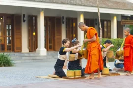 Buddhist monks receiving morning alms outside a luxury hotel in Luang Prabang, a signature cultural experience