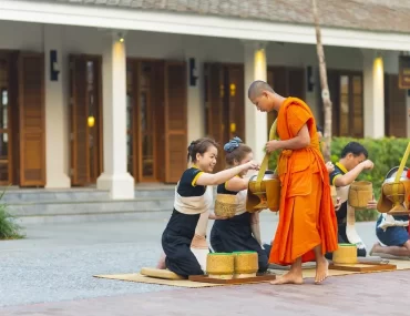 Buddhist monks receiving morning alms outside a luxury hotel in Luang Prabang, a signature cultural experience