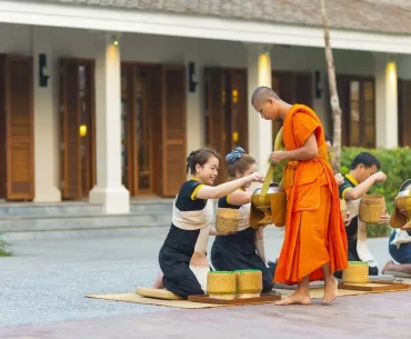 Buddhist monks receiving morning alms outside a luxury hotel in Luang Prabang, a signature cultural experience