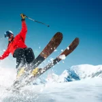 Skier in high-end gear enjoying fresh powder, showcasing a thrilling and luxurious skiing experience.