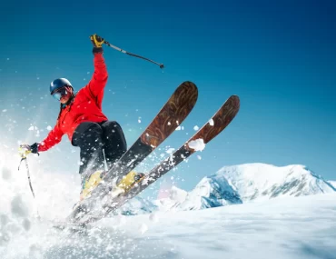 Skier in high-end gear enjoying fresh powder, showcasing a thrilling and luxurious skiing experience.