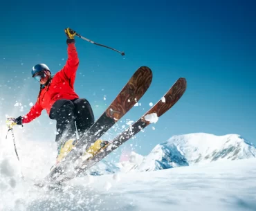 Skier in high-end gear enjoying fresh powder, showcasing a thrilling and luxurious skiing experience.