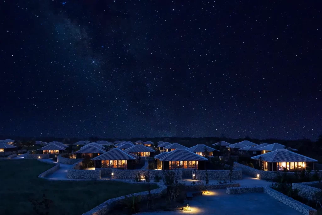 Luxury Japan tours and travel holidays featuring Hoshinoya Taketomi Island at night, showcasing traditional Okinawan villas under a spectacular starry sky and the Milky Way. An exclusive experience for a bespoke Japan DMC itinerary.