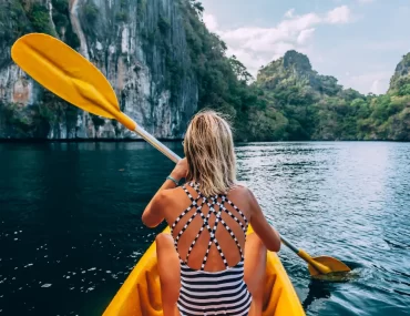 A traveler enjoying a bespoke kayaking journey through the limestone lagoons of Palawan, Philippines.