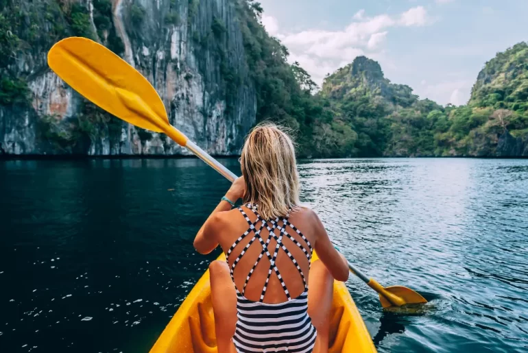 A traveler enjoying a bespoke kayaking journey through the limestone lagoons of Palawan, Philippines.