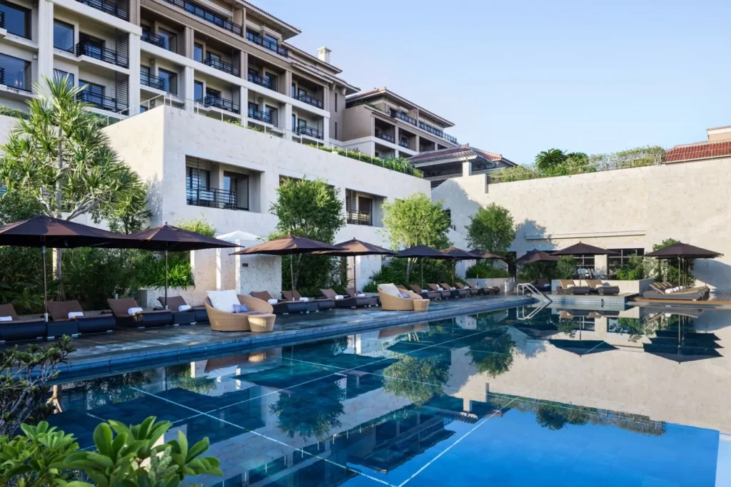 The stunning outdoor swimming pool and sun terrace at The Ritz-Carlton Okinawa. This luxury resort offers a perfect place to relax on high-end Japan travel and bespoke Japan DMC itineraries.