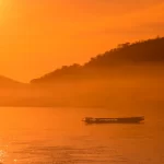 Luxury travel design for advisors – private boat on the Mekong at sunrise near Luang Prabang, Laos