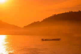 Luxury travel design for advisors – private boat on the Mekong at sunrise near Luang Prabang, Laos