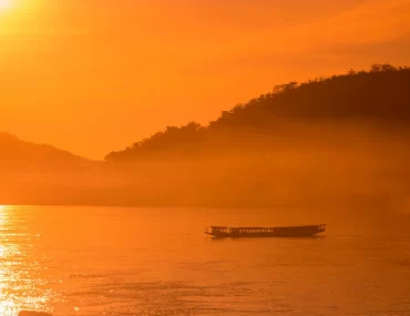 Luxury travel design for advisors – private boat on the Mekong at sunrise near Luang Prabang, Laos