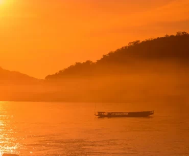 Luxury travel design for advisors – private boat on the Mekong at sunrise near Luang Prabang, Laos