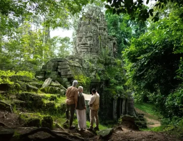 Couple with a private guide at a jungle-covered stone face gate of Angkor Thom, Cambodia. Photo courtesy of Park Hyatt Siem Reap