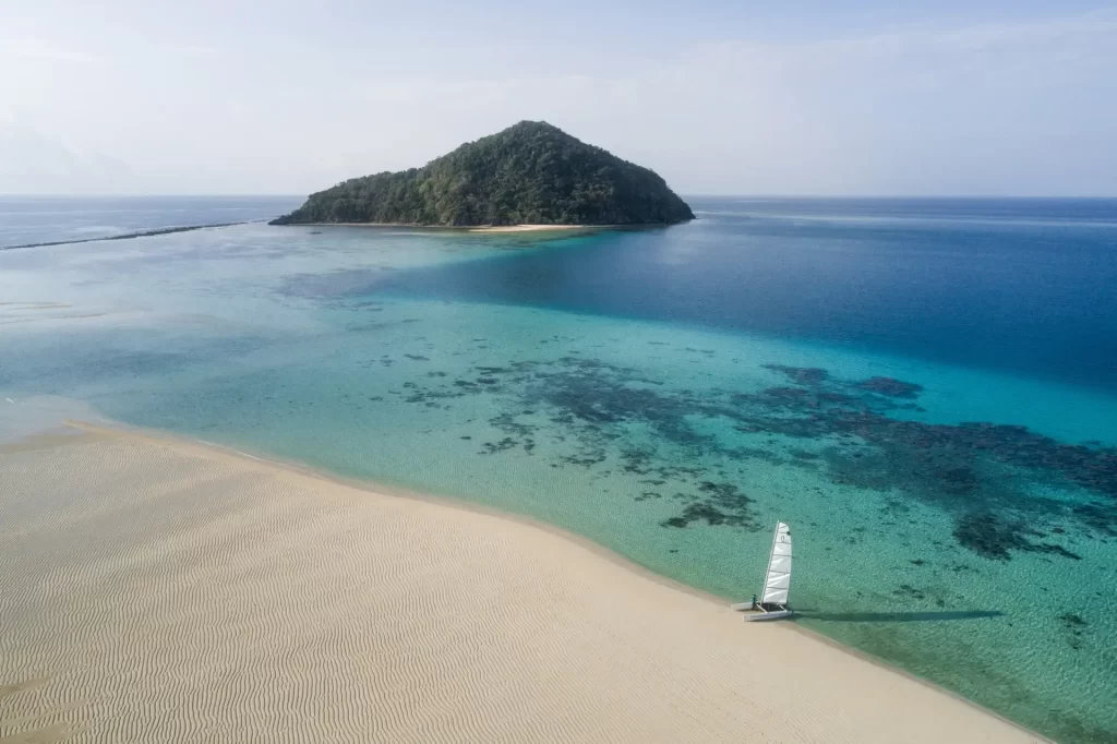Aerial view of a private sandbar, turquoise reef and jungle island at Bawah Reserve in the Anambas Islands, Indonesia – remote luxury in Southeast Asia