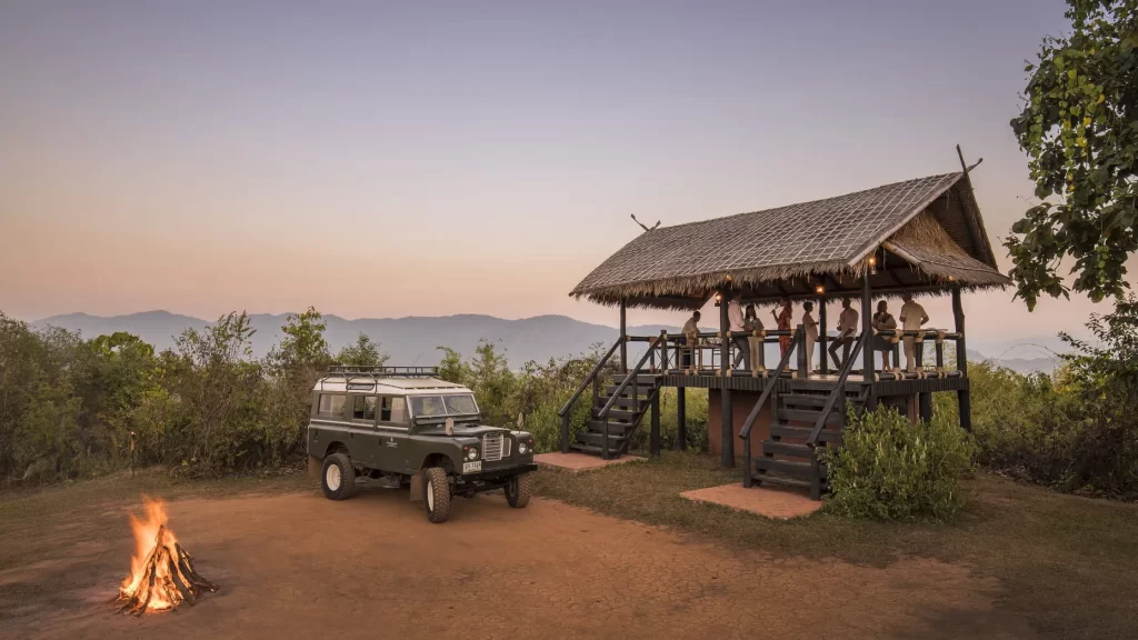 Private hilltop sundowner with a vintage Land Rover and campfire in the Golden Triangle, northern Thailand – seamless luxury logistics in remote Asia