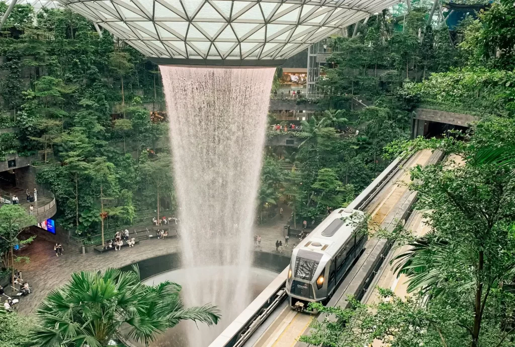 A train glides through the stunning Rain Vortex waterfall at Jewel Changi Airport