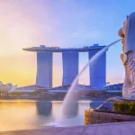 Iconic view of Singapore's Merlion Park with the Merlion statue in the foreground, Marina Bay Sands hotel and ArtScience Museum in the background, at sunrise