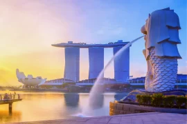 Iconic view of Singapore's Merlion Park with the Merlion statue in the foreground, Marina Bay Sands hotel and ArtScience Museum in the background, at sunrise