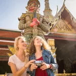 Two women on a luxury tour of the Grand Palace in Bangkok, Thailand.