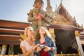 Two women on a luxury tour of the Grand Palace in Bangkok, Thailand.