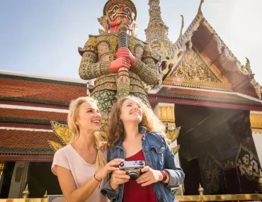 Two women on a luxury tour of the Grand Palace in Bangkok, Thailand.