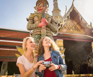 Two women on a luxury tour of the Grand Palace in Bangkok, Thailand.